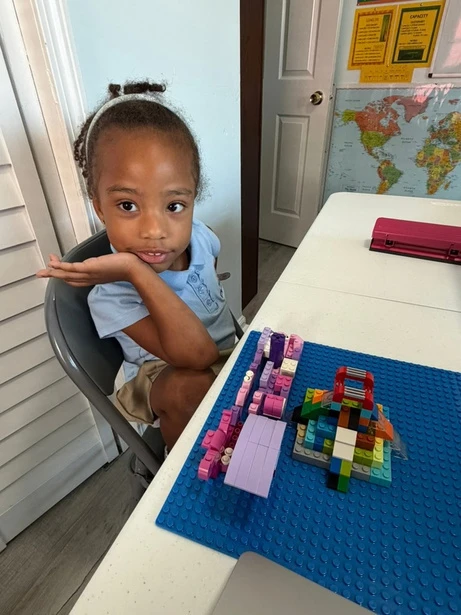 A student builds a colorful creation with blocks