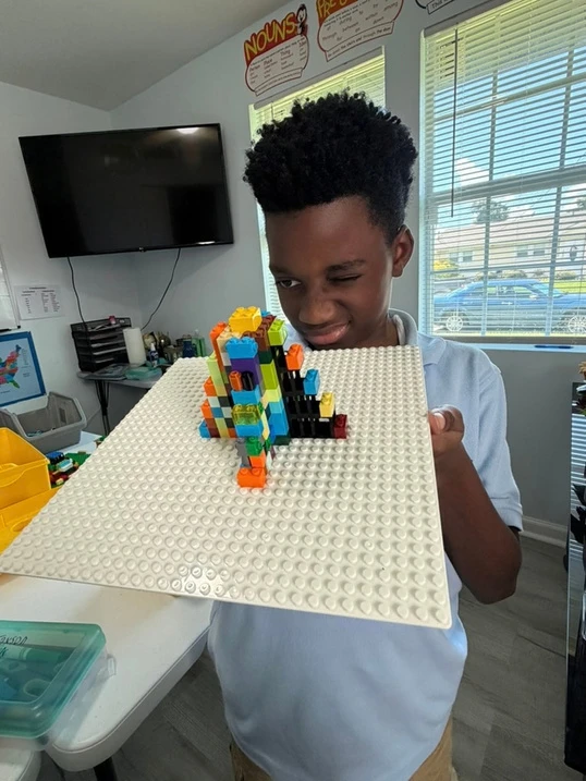 A student presents a model Mayan pyramid